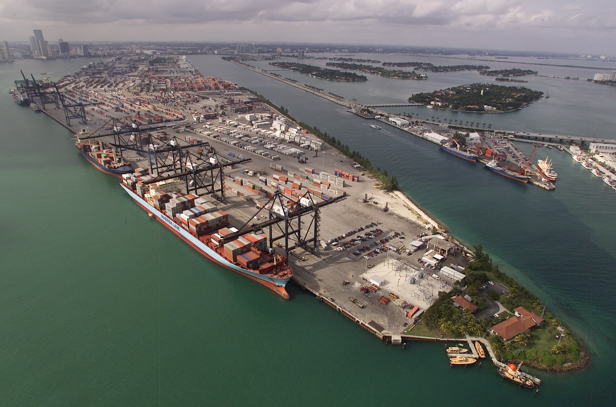 Aerial photograph of the container terminal at the Port of Miami, stacked containers and gantry cranes along the quay.